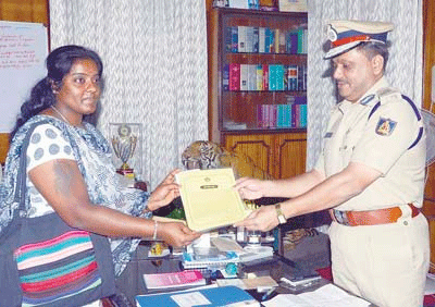 Mysuru Police chief MA Saleem giving certificate of appreciation to Chitra for fighting back the molester. DH