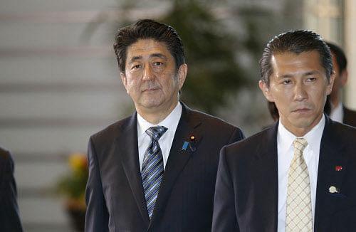 Japan's Prime Minister Shinzo Abe, left, arrives at the prime minister's official residence in Tokyo, Wednesday, Dec. 24, 2014. Abe won endorsement Wednesday to serve another term as prime minister after winning a renewed mandate for his 'Abenomics' strategies for reviving the world's third-biggest economy. AP photo