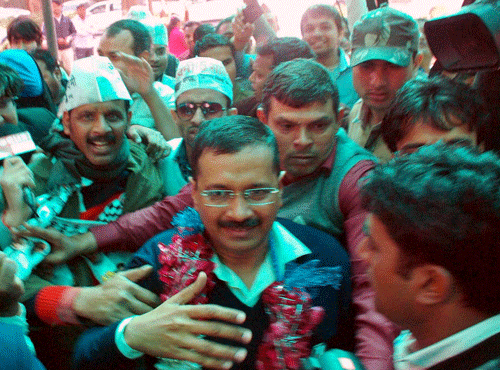 AAP convener Arvind Kejriwal along with suuporters arrives at the party office in Kaushambi on Tuesday after the party's win in Delhi Assembly polls. PTI Photo