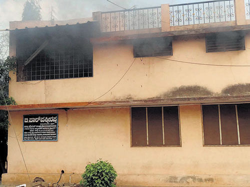 Smoke billows out of district sub-registrar's office building in Ballari on Sunday where a fire broke out due to short circuit. DH PHOTO