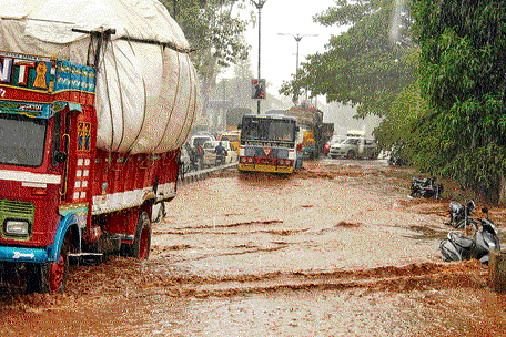 SPLASHY RIDE: Heavy rains led to waterlogging on the busy Belagavi-Khanapur Road in Belagavi on Saturday.  DH Photo