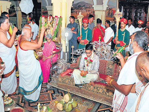 gala preparations: Yaduveer Krishnadatta Chamaraja Wadiyar, the adopted son of Pramoda Devi Wadiyar, takes part in a  ritual related to coronation ceremony at Amba Vilas Palace in Mysuru on Wednesday. (R) A procession is being taken as part of the ceremony. dh Photos
