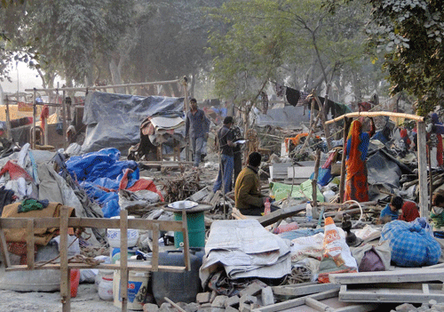 People collect their belongings after a demolition drive carried out by railways in Shakur Basti of Delhi on Sunday. PTI Photo