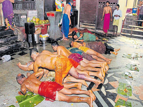 banned Devotees perform 'made snana' by rolling over leaves with leftover food at a  temple in Udupi on Thursday. DH PHOTO