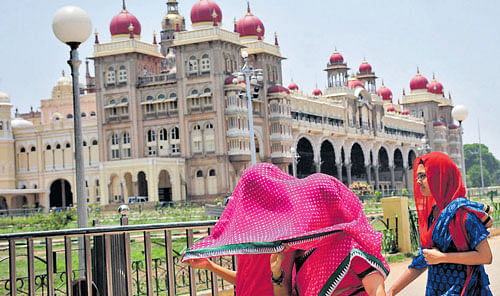 Visitors to Amba Vilas Palace, Mysuru cover themselves with clothes to avoid sun, on  Monday. DH Photo/IRSHAD MAHAMMAD