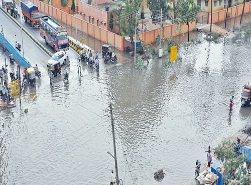 Motorists struggle to navigate the old Pune-Bengaluru Road in Davangere following heavy rainfall on Tuesday. DH PHOTO