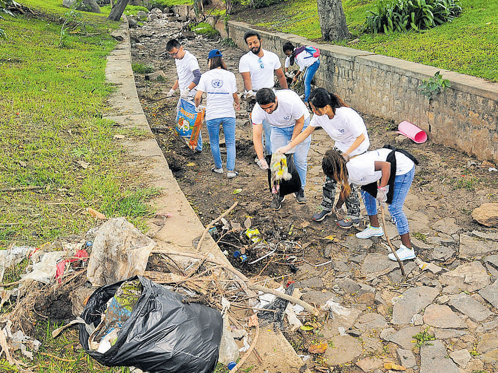 Foreign students during the cleanliness drive at Rajkumar Park in Mysuru recently. DH photo