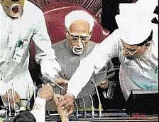 A TV grab shows SP and RJD MPs trying to snatch copies of the Womens Reservation Bill from Rajya Sabha Chairman Hamid Ansari to prevent its tabling in the House in New Delhi on Monday. PTI/Courtesy Lok Sabha TV