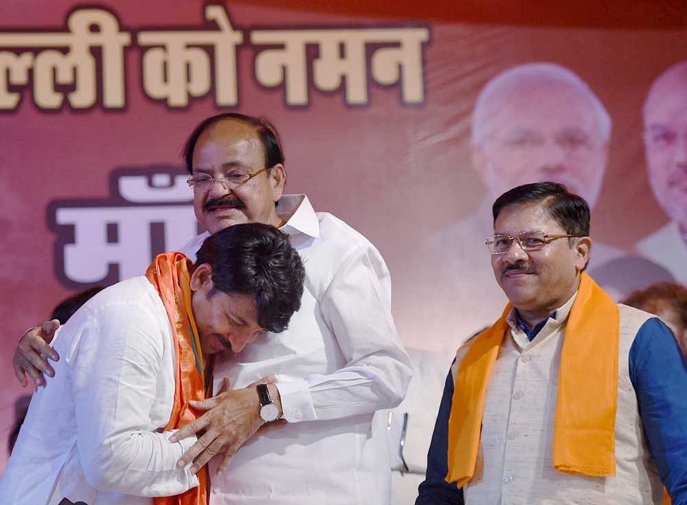Union Minister M Venkaiah Naidu greets Delhi BJP President, Manoj Tiwari as party's Delhi incharge Shyam Jaju (R) looks on during a press conferecne after the party's huge victory in the MCD elections, in New Delhi on Wednesday. PTI Photo