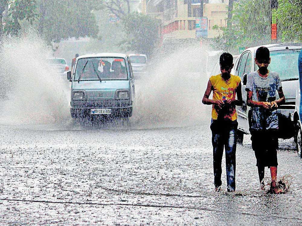 Making a splash: A van passes through a waterlogged road following heavy rainfall in Bhopal on Monday. PTI