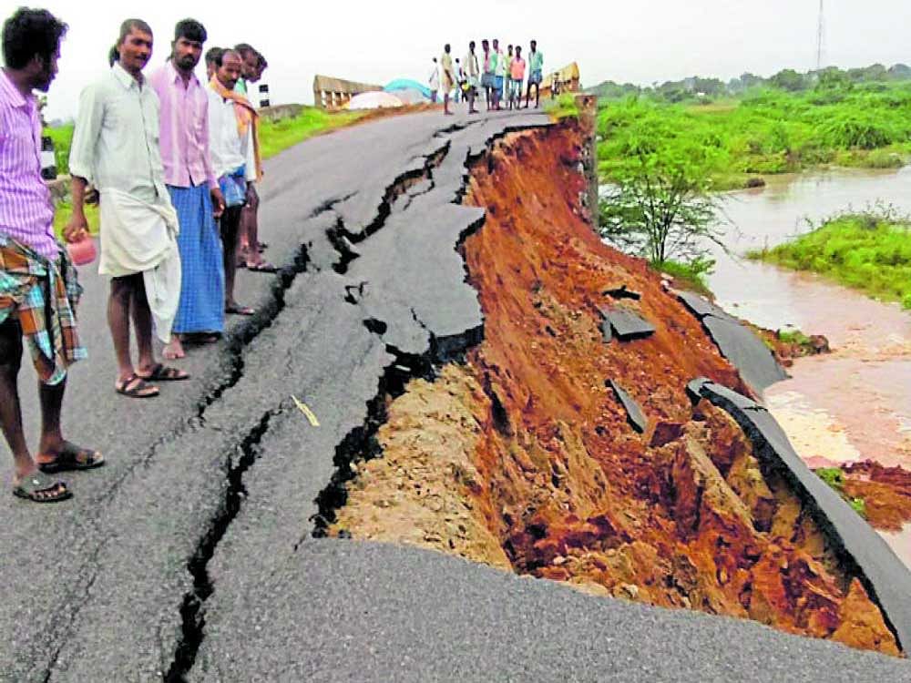 A portion of the newly laid road has been washed away in the overnight rain near Shirur in Koppal district on Saturday. Motorists struggle to negotiate  the flooded road at Chandramouleshwara Circle in Raichur on Saturday. The town expereinced downpour on Saturday afternoon.