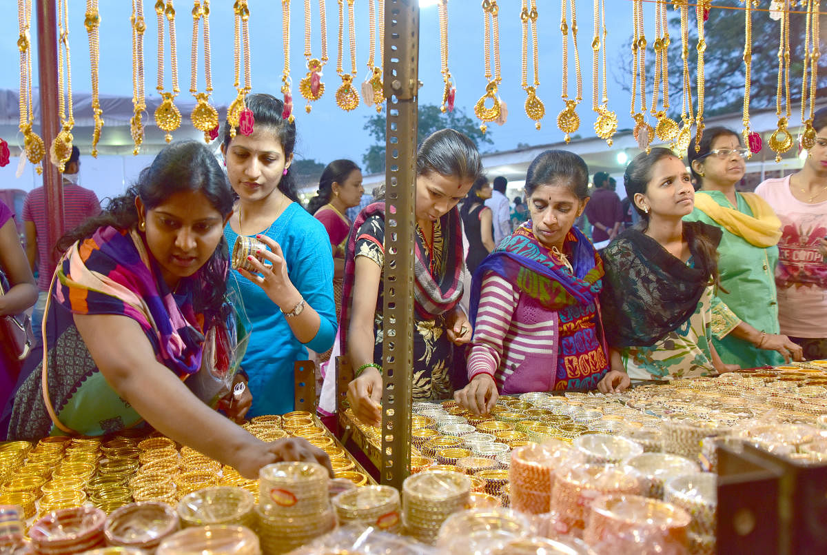 Women buy artificial jewels from a make-shift shop, during the 83rd Akhila Bharatha Kannada Sahithya Sammelana, near the University of Mysore Sports Pavilion, in Mysuru, on Sunday. DHPHOTO