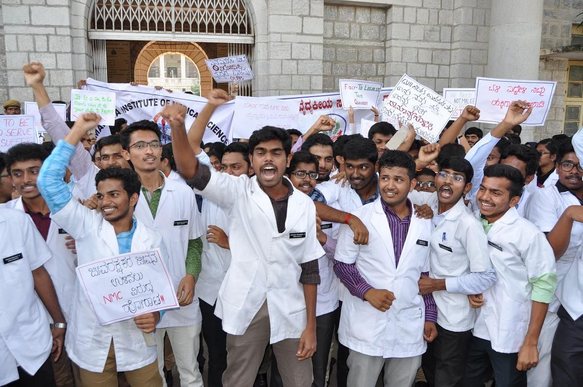 Medical students stage a protest against setting up of the National Medical Council, near the Deputy Commissioner's office in Mandya on Tuesday.