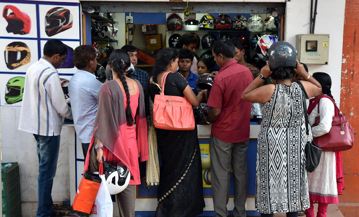Riders purchase ISI mark helmets at a shop on Chamaraja Double Road in Mysuru on Thursday. dh photo