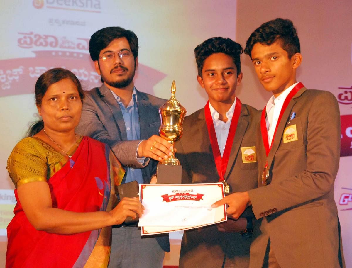 B T Tanush and R Akash of Amber Valley Residential School, Chikkamagaluru, winners of the zonal level Prajavani Quiz Championship, held in Hassan, on Tuesday. ZP CEO K M Janaki and Karthik Kote of Deeksha Institutions are seen.