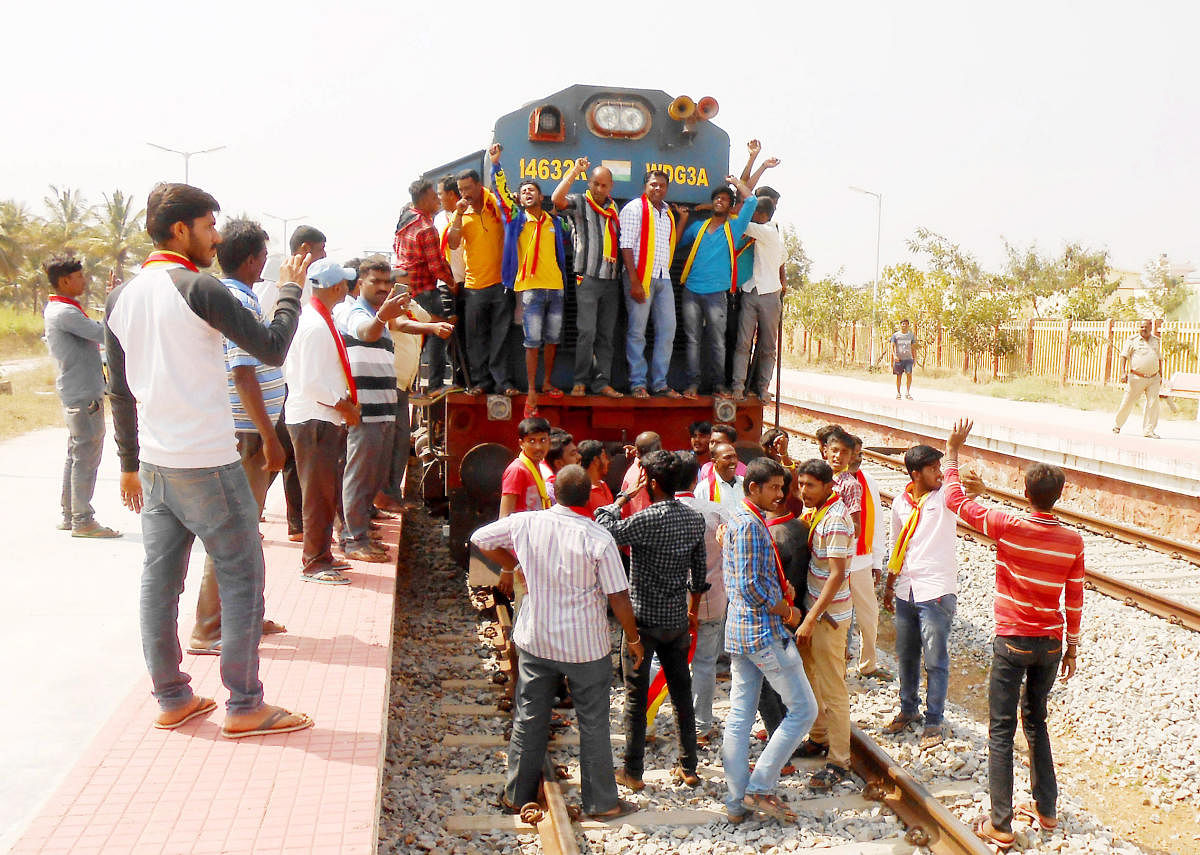 Members of a Kannada organisation stage a protest by blocking the Hassan-Bengaluru train, at Hirisave Railway Station, in Hassan district on Thursday.