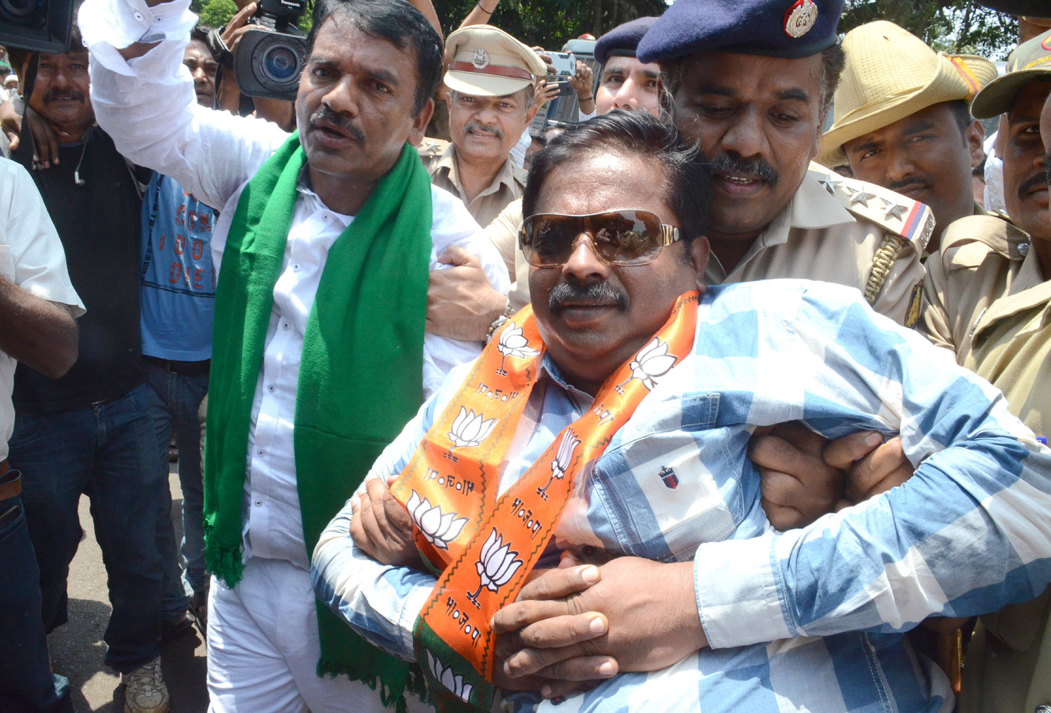 BJP MLAs Abhay Patil and Anil Benke being detained by police during bandh call given by BJP demanding waiver of farmers loans and staging sit-in protest at Channamma Circle in Belagavi on Monday. (DH Photo)