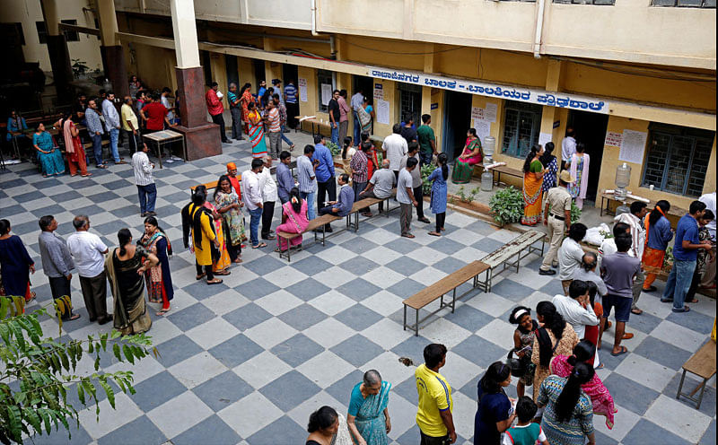 Voters wait in queues to cast their ballot outside a polling station during Karnataka assembly elections in Bengaluru, India, May 12, 2018. REUTERS