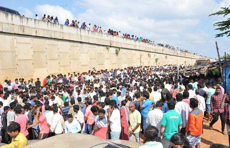 A large number of people gather on the service road in Tumakuru the former Mayor Ravi Kumar was hacked to death on Sunday. (DH Photo)