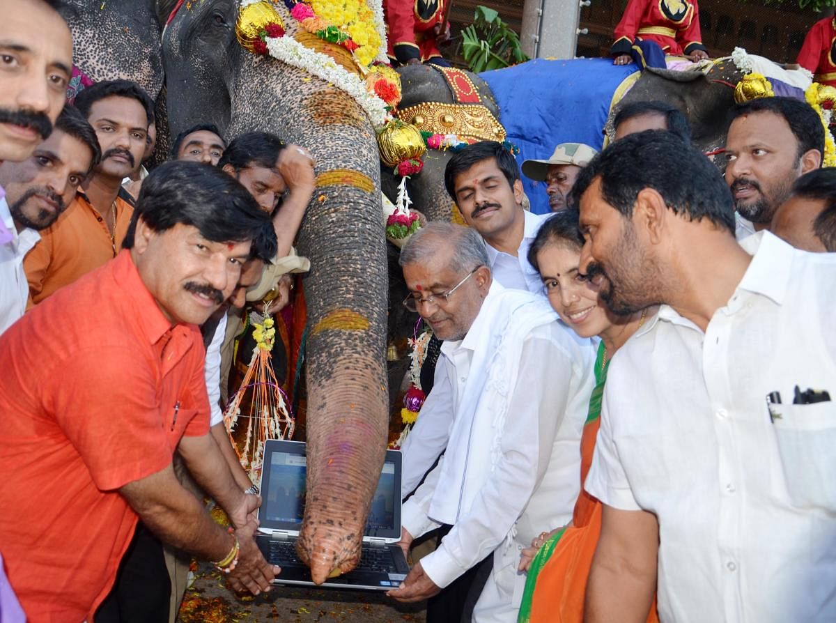 Dasara elephant Arjuna launches Mysuru Palace official website in Mysuru Palace, on Wednesday. Minister G T Deve Gowda, MLAs S A Ramdas, Nagendra are seen. 