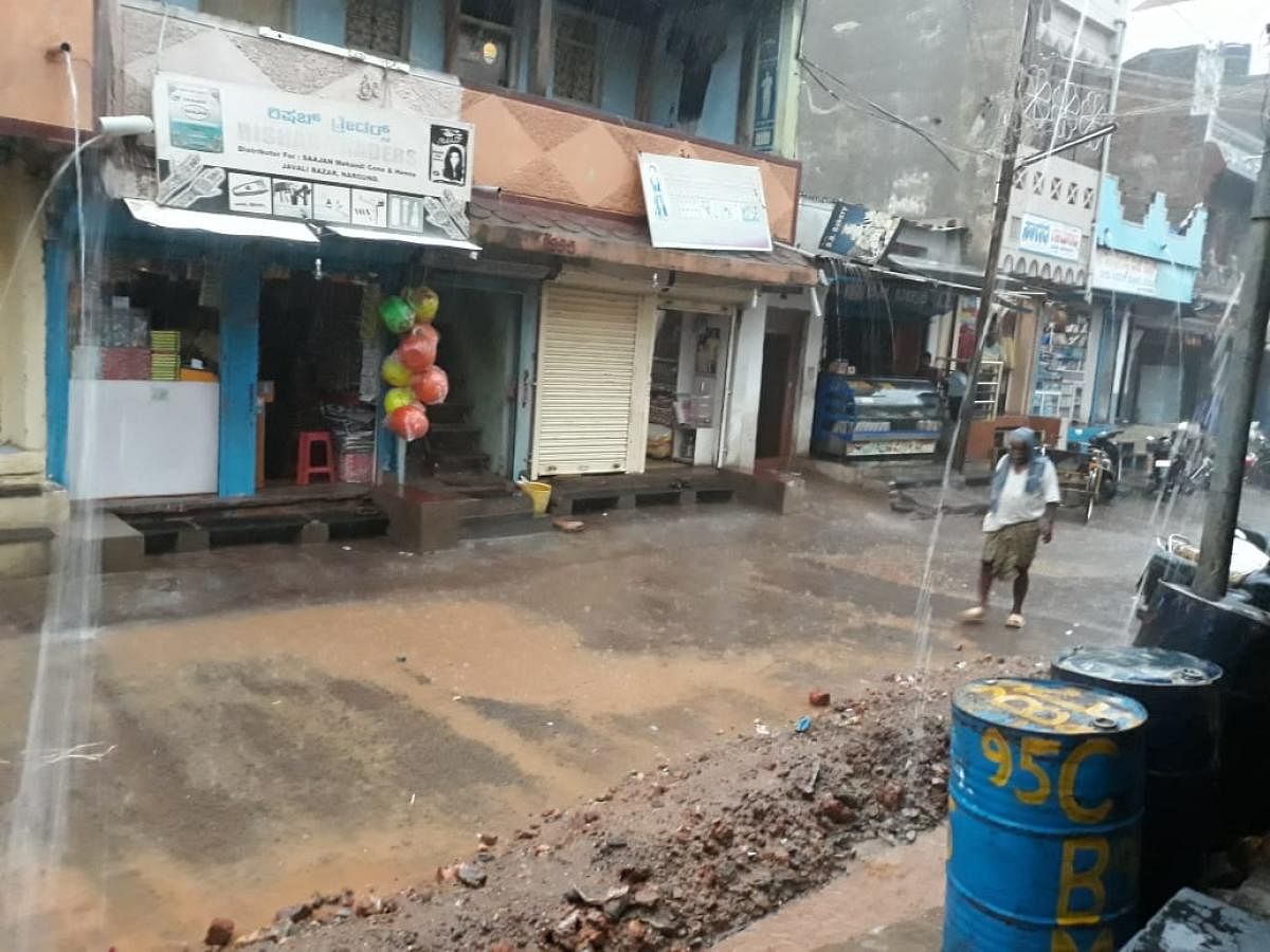Heavy rain lashes Nargund town in Gadag taluk on Monday. (Right) The KSRTC bus stand in Chamarajanagar was flooded due to downpour on Monday. DH Photos