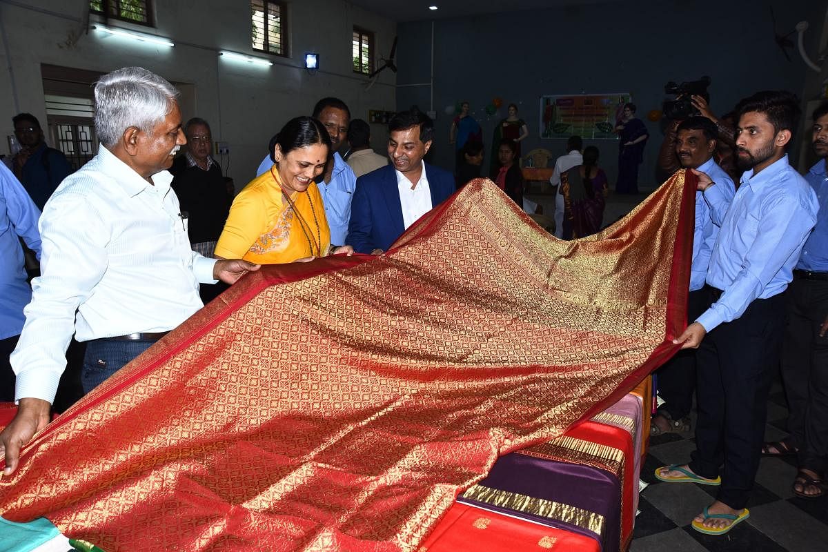 Dimhans administrative officer Sharada Kolakar and others look at a saree at the inauguration of the four-day Mysore Silk exhibition-cum-sale at Bhagini Mandal at J C Nagar in Hubballi on Tuesday.
