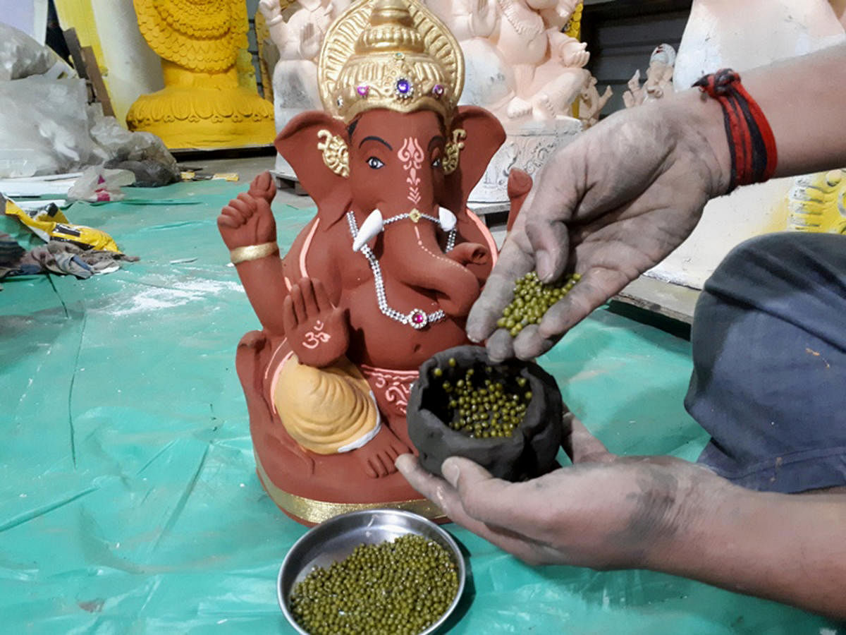 Greengram seeds are put inside the Ganesh idols before handing them over to devotees. (DH Photo)