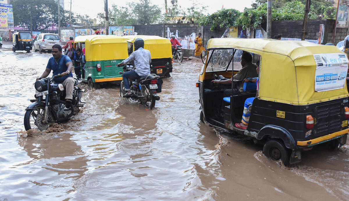 Vehicles wade through the waterlogged Ashoka Road in Davangere on Friday. The city has been receiving good spells of rain for the past two days. DH PHOTO