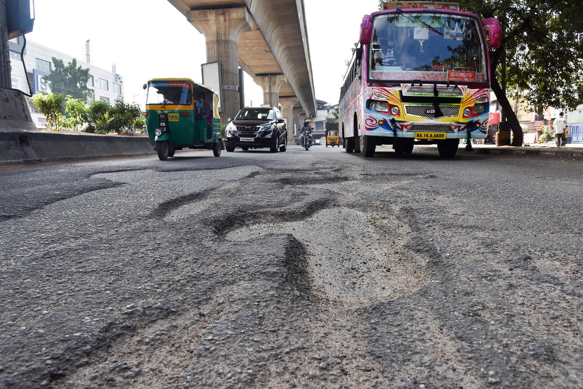 A pothole-ridden Tumakuru Road near the RMC Yard bus stop. DH Photo/B H Shivakumar