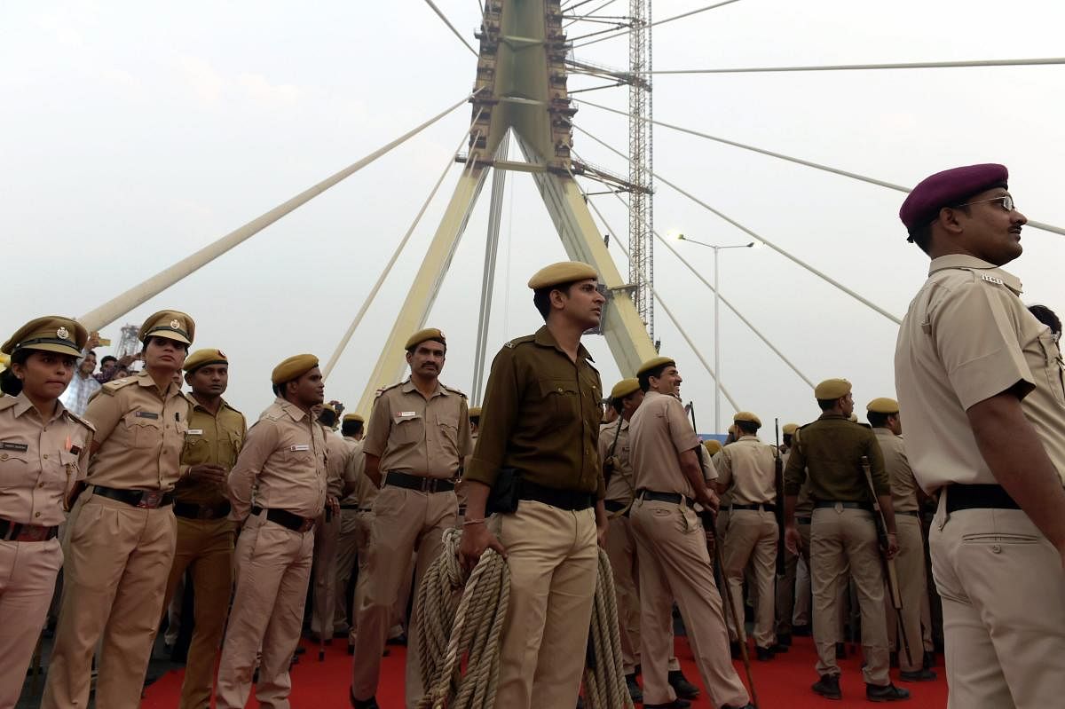 Policemen look on during the inauguration of the Signature Bridge at Wazirabad in New Delhi, on Sunday. PTI file photo