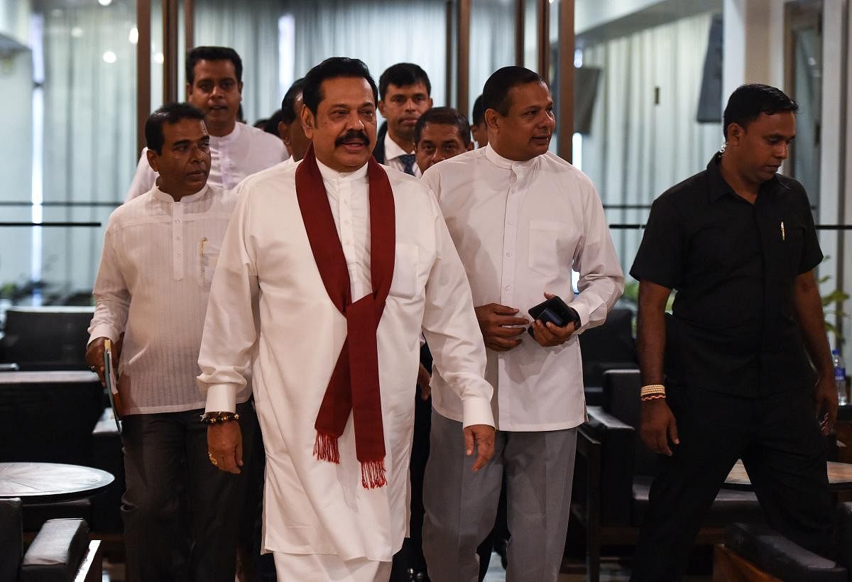 Sri Lanka's former president and currently appointed prime minister Mahinda Rajapakse (C) arrives at the parliament in Colombo on November 29, 2018. AFP