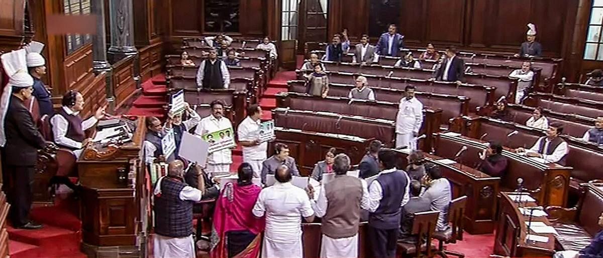 Opposition members protest in the Rajya Sabha during the Winter Session of Parliament, in New Delhi on Wednesday. PTI