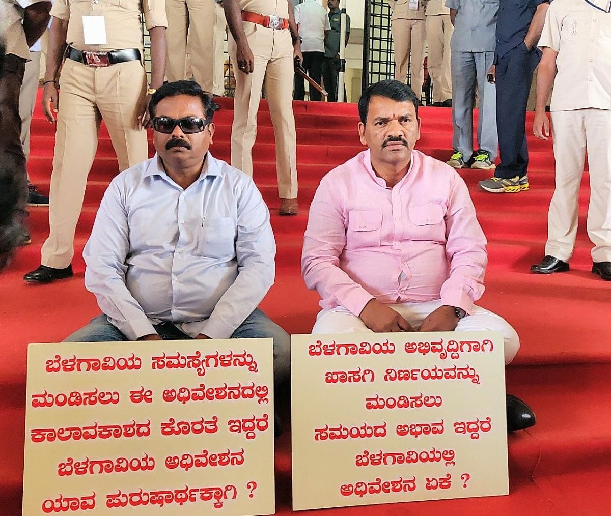 MLAs Abhay Patil and Anil Benke staging sit-in protests at the entrance of SVS in Belagavi for the former not being allowed to table private members bill for taking up Belagavi issues in the house. DH Photo.