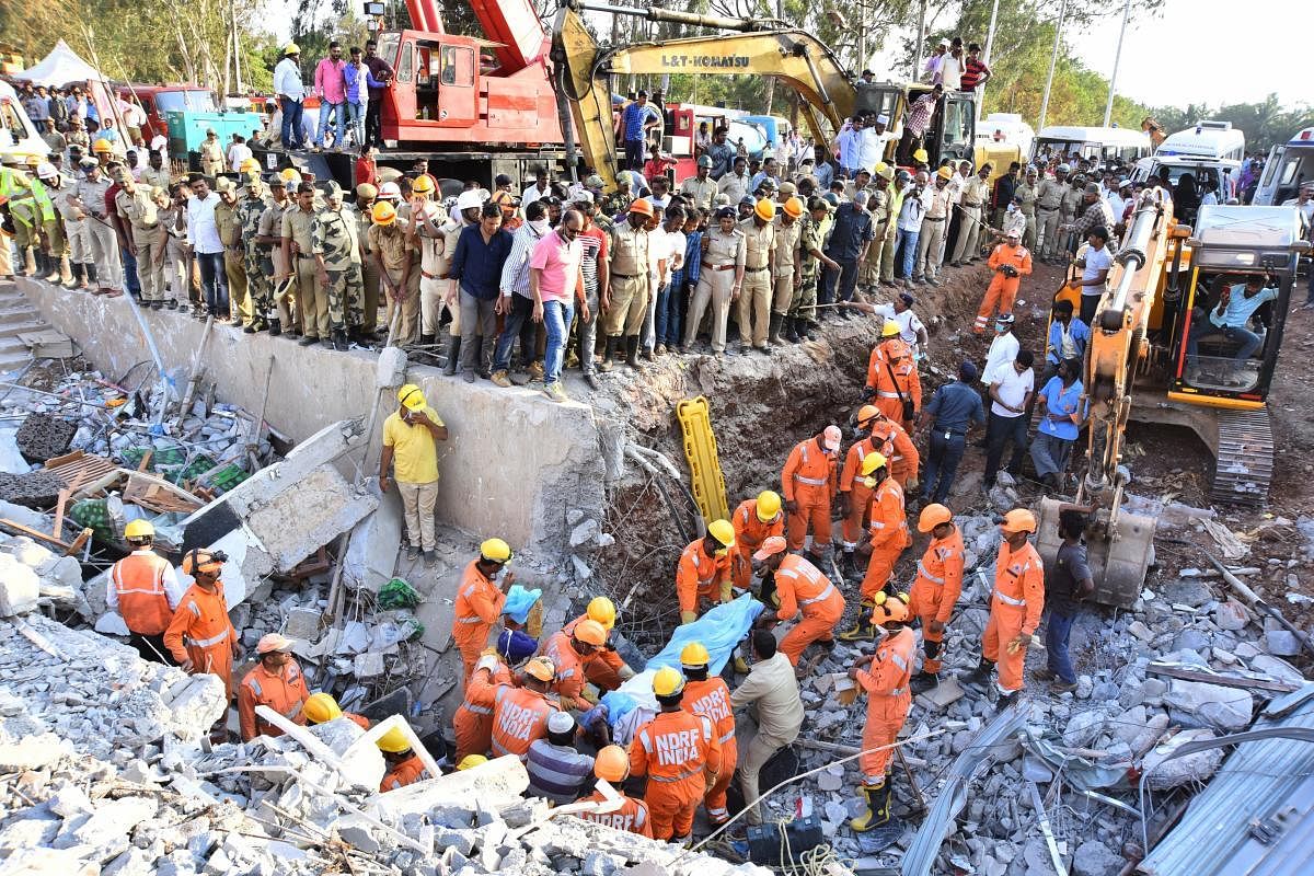 Personnel of the National Disaster Relief Force retrieve the body of a victim from under the debris of the collapsed building in Dharwad on Wednesday. dh photo/Tajuddin Azad