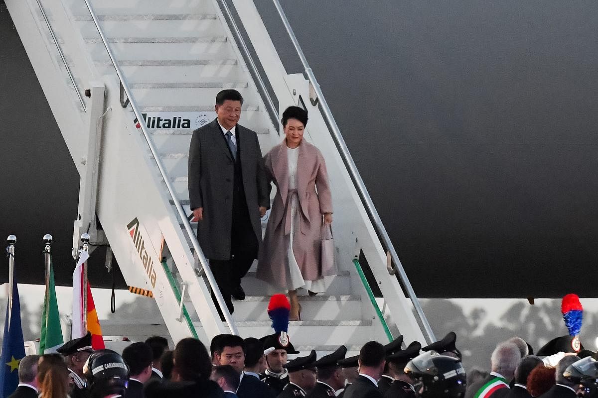 China's President Xi Jinping (L) and his wife Peng Liyuan get down their plane after landing at Rome's Fiumicino airport for a two-day visit in Italy. AFP
