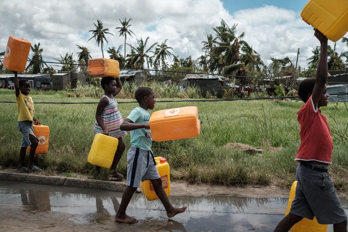 TOPSHOT - Children carry empty tanks to get water in Beira, Mozambique, March 21, 2019, ahead of World Water Day. - Each year on March 22, World Water Day is observed around the world, focusing on the importance of freshwater and advocating for sustainabl