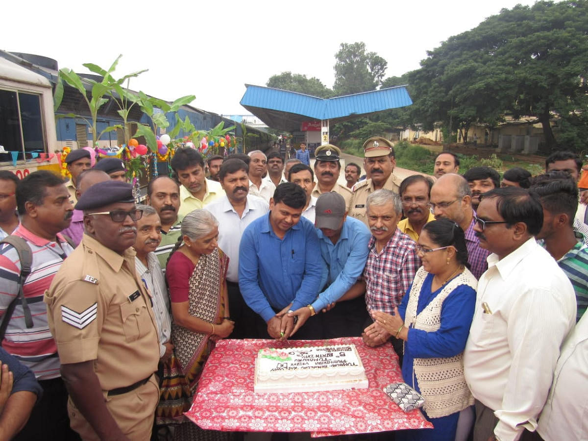 Passengers and officials cut a cake to mark the fifth anniversary of Tumakuru-Bengaluru Fast Passenger at the Tumakuru railway station on Friday. 