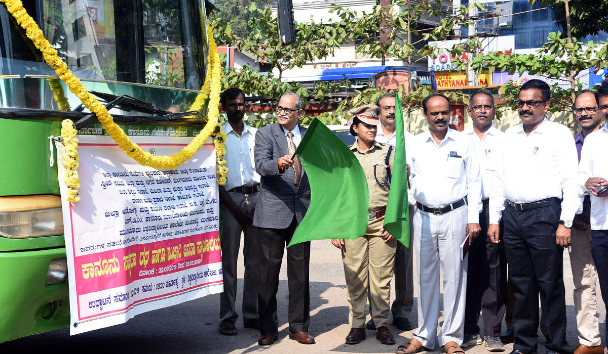 Principal District and Sessions Judge Kadluru Satyanarayanacharya flags off the Legal Awareness Chariot and the Mobile Janata Court on the premises of the University College in Mangaluru on Friday.