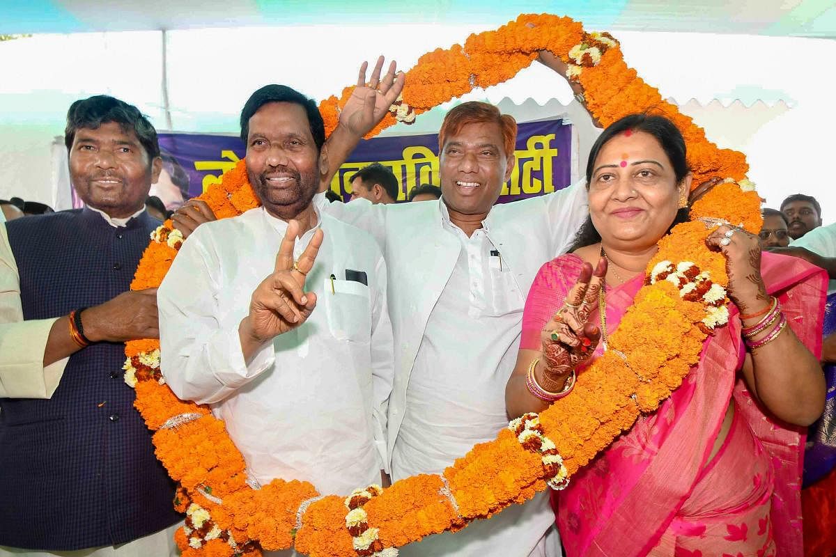 Patna: Lok Janshakti Party Hajipur candidate Pashupati Paras, Samastipur candidate Ramchandra Paswan and BJP's former MLA and Vaishali candidate Veena Devi wear garland with party Chief Ram Vilas Paswan during a press conference, in Patna, Saturday, March 23, 2019. (PTI Photo)