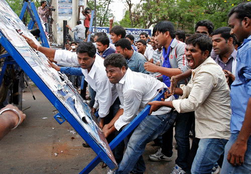 Pro-Telangana supporters overturn a barricade during a protest rally in the southern Indian city of Hyderabad. The demonstrators were demanding a separate Telangana state carved out of Andhra Pradesh, supporters said. REUTERS