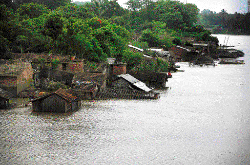 SINKING in: Houses in a village near the Mahananda river partially submerged in water as the flood entered the nearby area in Malda on Thursday. PTI