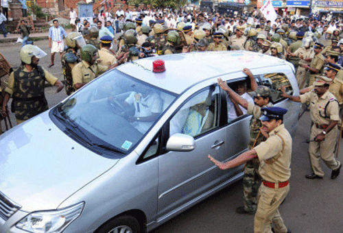 Police try to protect Kerala Chief Minister Oommen Chandy's vehicle during the stone pelt by LDF workers in Kannur on Sunday.PTI Photo