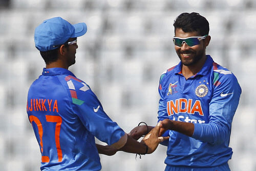 Ravindra Jadeja, right, celebrates with his teammate Ajinkya Rahane after the dismissal of Afghan cricket player Asghar Stanikzai during the Asia Cup one-day international cricket tournament against India in Dhaka, Bangladesh, Wednesday, March 5, 2014. AP Photo