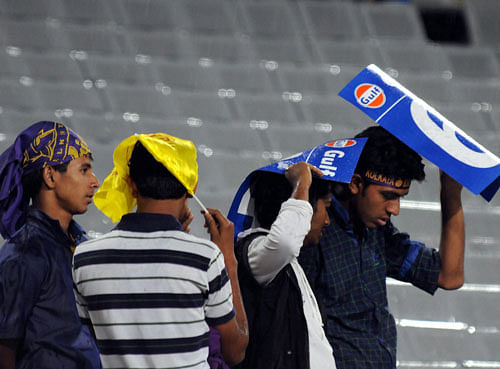 Cricket fans try to save themselves during rains ahead of an IPL match between Chennai Super Kings and Kolkata Knight Riders in Ranchi on Friday. PTI Photo