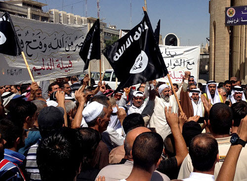 Demonstrators chant pro-al-Qaida-inspired Islamic State of Iraq and the Levant (ISIL) as they wave al-Qaida flags in front of the provincial government headquarters in Mosul, 225 miles (360 kilometers) northwest of Baghdad, Iraq, Monday, June 16, 2014. Sunni militants captured a key northern Iraqi town along the highway to Syria early on Monday, compounding the woes of Iraq's Shiite-led government a week after it lost a vast swath of territory to the insurgents in the country's north AP photo