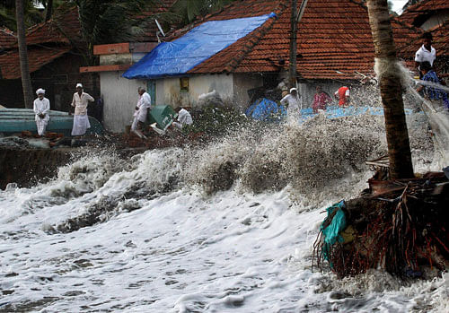 Hitting hard: People look on as sea waves strike the shore in Kozhikode on Thursday. PTI