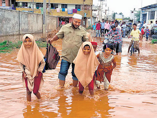 Marooned: Schoolchildren had a tough time reaching their homes as a bridge submerged in water in Hospet. dh photos
