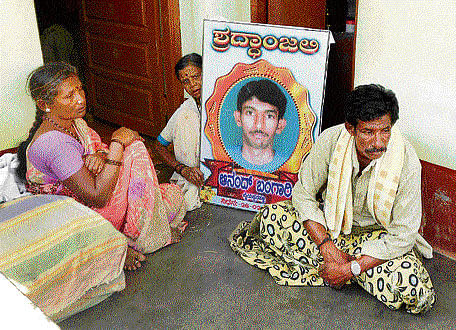 Sampangi Ramaiah mourns his son Anand's death, along with relatives at their house in Chikkaballapur. DH photo