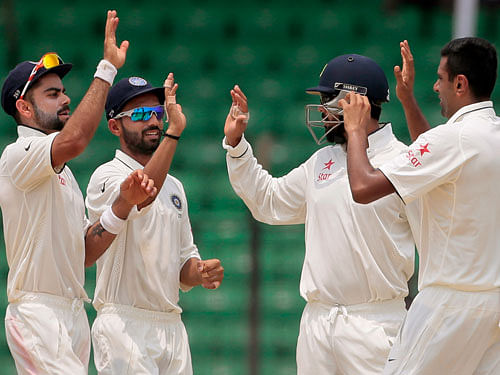India's Ravichandran Ashwin, right, celebrates with teammates Virat Kohli, left, Ajinkya Rahane, second left, and Murali Vijay the dismissal of Bangladesh's Shakib Al Hasan on the last day of the test cricket match between them in Fatullah, Bangladesh, Sunday, June 14, 2015. AP