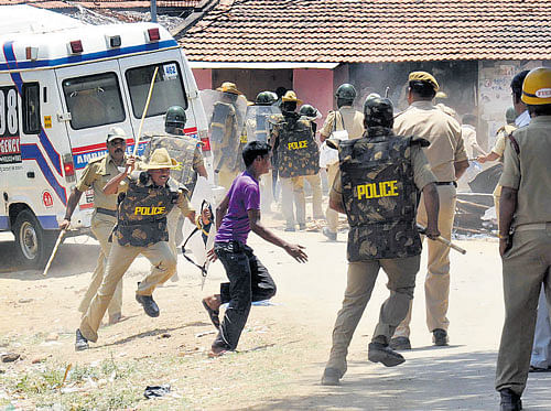 Police resort to caning to control the violence at Honganuru village near Chamarajanagar on Thursday. DH PHOTO